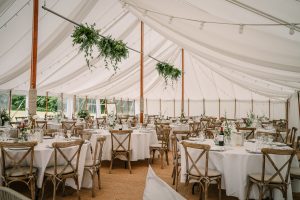 Traditional pole marquee. unlined. round tables crossback chairs